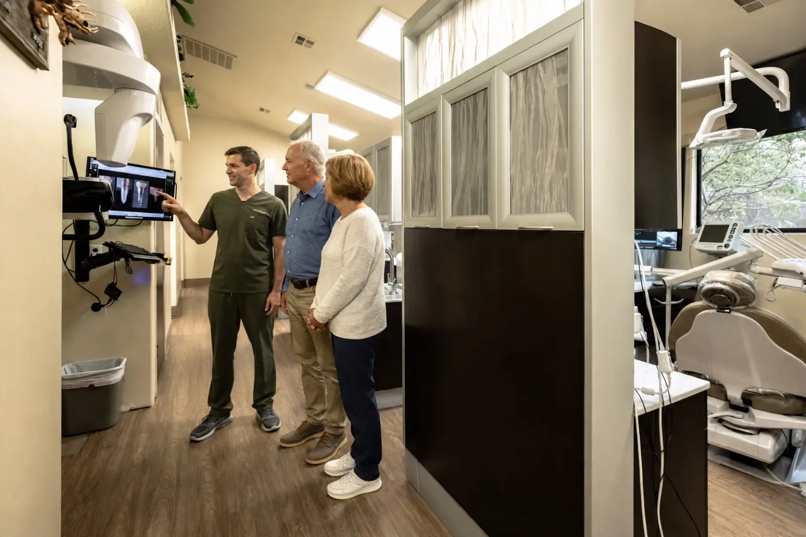 The team explaining implant options beside the imaging suite